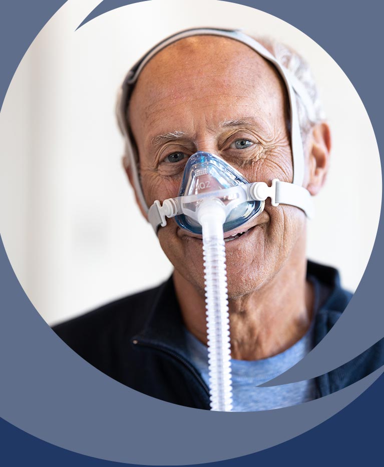 Man smiling wearing a nasal CPAP mask